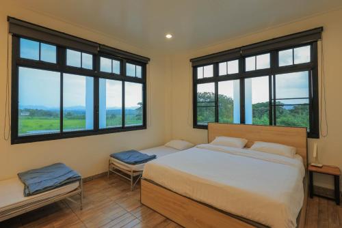 a bedroom with two beds and two windows at Phu Plearn Ta Pool Villas Khaoyai in Ban Bung Toei