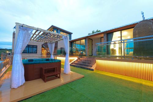 a house with a jacuzzi in the yard at Phu Plearn Ta Pool Villas Khaoyai in Ban Bung Toei
