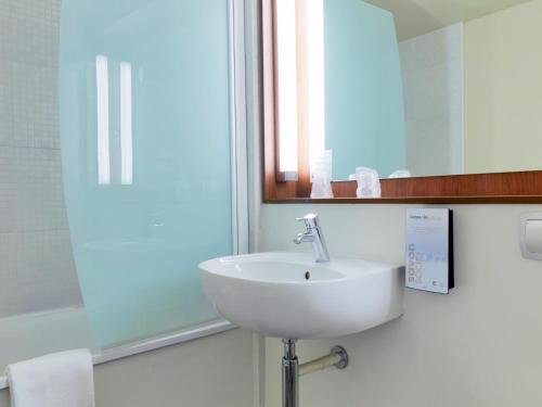 a bathroom with a white sink and a mirror at Campanile Pont-à-Mousson in Pont-à-Mousson