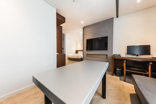a living room with a white table and a tv at CS Premier Hotel in Seoul