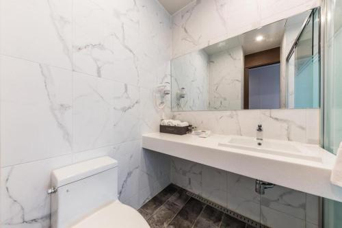 a white bathroom with a sink and a toilet at CS Premier Hotel in Seoul
