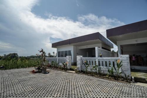 a house with a white fence in front of it at Taman Villa Kelating in Krambitan