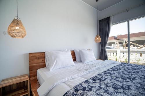 a bedroom with a bed and a large window at Taman Villa Kelating in Krambitan