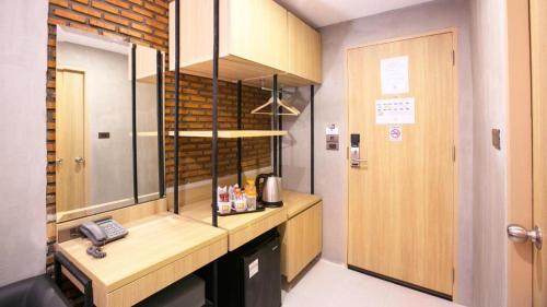 a kitchen with a desk and a phone in a room at B2 Mukdahan Boutique and Budget Hotel in Mukdahan