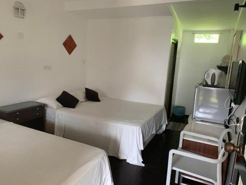a hotel room with two beds and a tv at Nipah Bay Villa in Pangkor