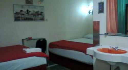 a hotel room with two beds and a sink at Mitra Hotel Yogyakarta in Yogyakarta