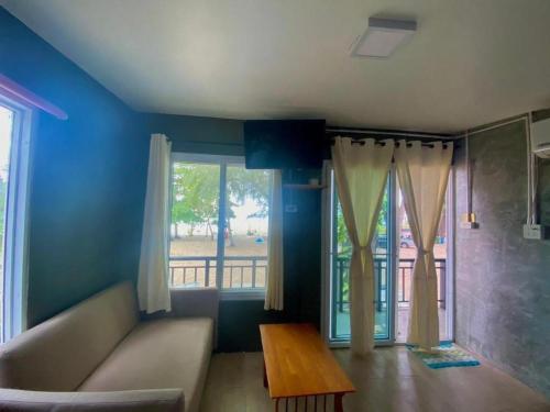 a living room with a couch and a table and a window at Hat yao Seaview Beach Room in Trang