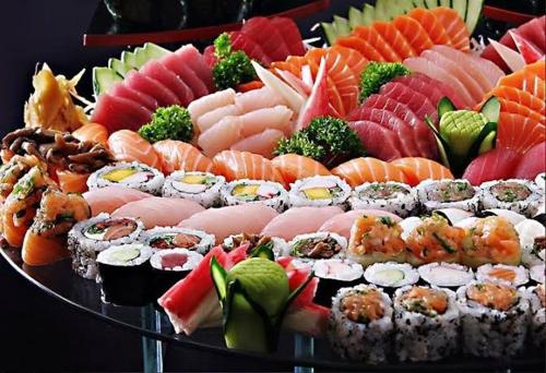 a platter of sushi and vegetables on a plate at Hostel Anprado 1 in Guarulhos