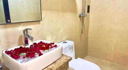 een badkamer met een wastafel met rode bloemen erin bij Hotel 007 in Sihanoukville