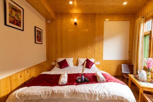 a bedroom with a bed in a room with wooden walls at The Evara Stays, Jibhi in Jibhi