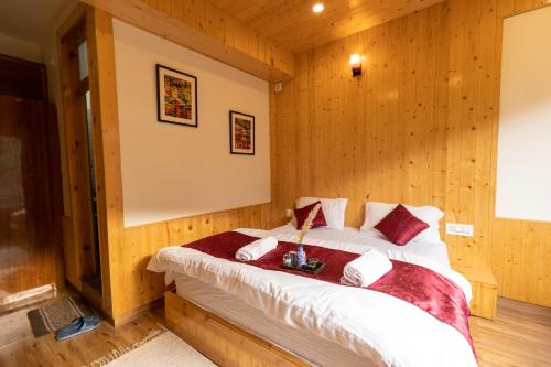 a bedroom with a bed in a wooden room at The Evara Stays, Jibhi in Jibhi