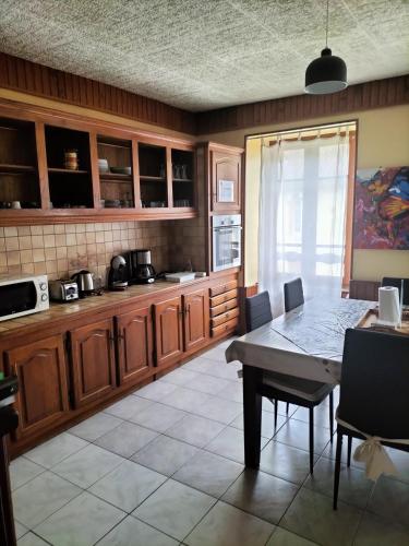 une cuisine avec des armoires en bois et une table avec des chaises dans l'établissement La Caminada, à Fougax-et-Barrineuf