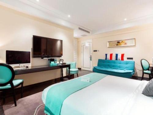 a hotel room with a large bed and a tv at Xana Hotelle· Tianjin Railway Station Jinwan Square Binjiang Avenue in Tianjin