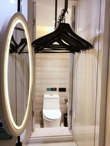 a bathroom with a mirror and a toilet at Xana Hotelle· Tianjin Railway Station Jinwan Square Binjiang Avenue in Tianjin