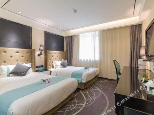 a hotel room with two beds and a television at Xana Hotelle· Tianjin Railway Station Jinwan Square Binjiang Avenue in Tianjin