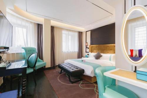a bedroom with a bed and a mirror and a desk at Xana Hotelle· Tianjin Railway Station Jinwan Square Binjiang Avenue in Tianjin