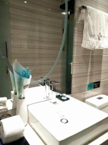 a bathroom with a sink and a mirror at Xana Hotelle· Tianjin Railway Station Jinwan Square Binjiang Avenue in Tianjin