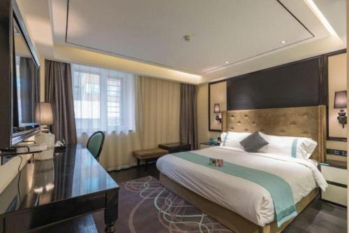 a hotel room with a large bed and a television at Xana Hotelle· Tianjin Railway Station Jinwan Square Binjiang Avenue in Tianjin