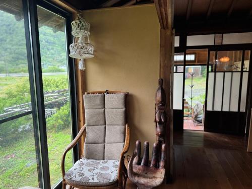 a room with a chair and a chandelier at 六弥苑 in Matsuzaki