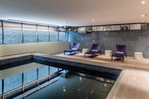 a swimming pool with two chairs sitting next to it at Blue Tree Premium Alphaville in Barueri