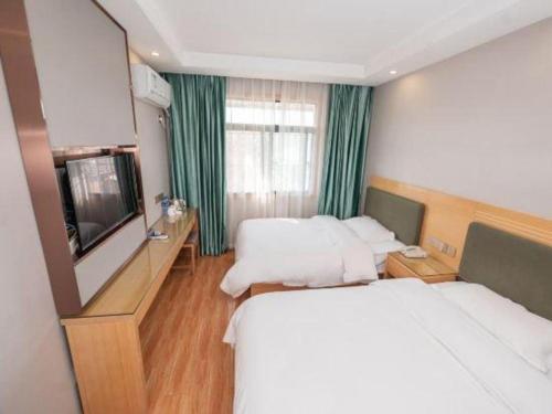 a hotel room with two beds and a flat screen tv at Shell Hefei Luyang District Sipai Building Subway Station Hotel in Hefei