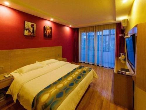 a bedroom with a bed and a flat screen tv at Shell Hefei Luyang District Sipai Building Subway Station Hotel in Hefei