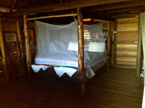 a bed with a canopy in a cabin at Ecolodge Tubagua Puerto Plata in Tubagua
