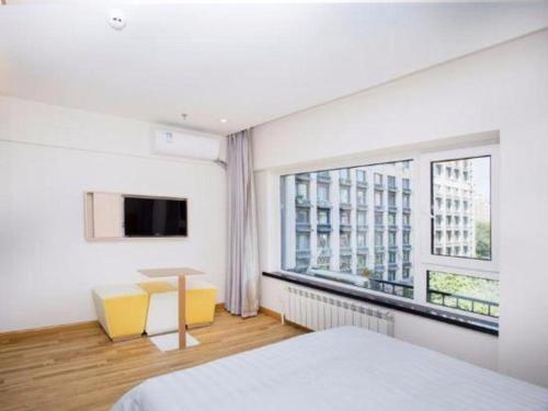a bedroom with a bed and a large window at 7 Days Inn Harbin West Railway Station in Harbin
