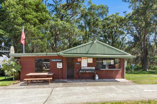 a small building with a picnic table and a bench at Shoalhaven Heads Village in Shoalhaven Heads