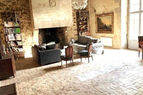 - un salon avec un canapé, des chaises et une cheminée dans l'établissement Manoir 15 mn des plages, à Hénansal