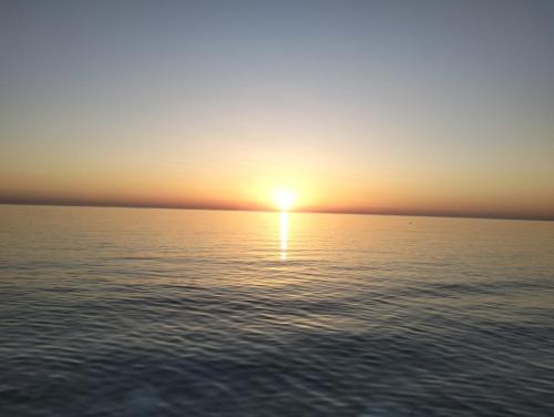 a sunset over the water with the sun setting at Casa dei gerani in Montegiordano