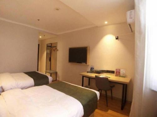 a hotel room with two beds and a desk at GreenTree Inn Xuzhou High Speed Railway Station Express Hotel in Xuzhou