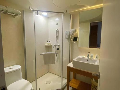 a bathroom with a shower and a toilet and a sink at GreenTree Inn Xuzhou High Speed Railway Station Express Hotel in Xuzhou