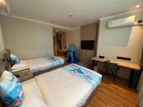 a hotel room with two beds and a desk and a desk at GreenTree Inn Xuzhou High Speed Railway Station Express Hotel in Xuzhou