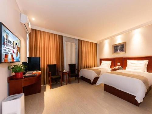 una camera d'albergo con due letti e una TV a schermo piatto di GreenTree Inn Beijing Tonzhou Maju Bridge No.2 Express Hotel a Pechino