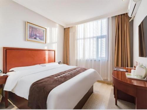 una camera d'albergo con un letto grande e una scrivania di GreenTree Inn Beijing Tonzhou Maju Bridge No.2 Express Hotel a Pechino