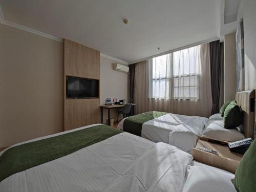 a hotel room with two beds and a television at GreenTree Inn Xuzhou High Speed Railway Station Express Hotel in Xuzhou