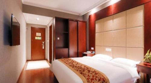 a bedroom with a large white bed and a television at GreenTree Inn Suzhou Shihu Suli Road Express Hotel in Suzhou
