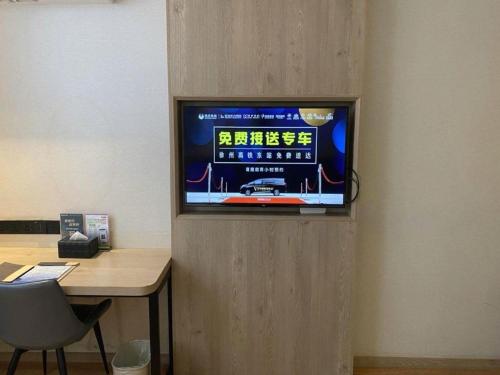 a television on a wall in a room at GreenTree Inn Xuzhou High Speed Railway Station Express Hotel in Xuzhou