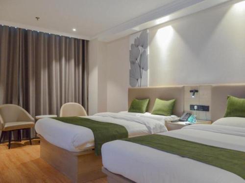 two beds in a hotel room with green accents at GreenTree Inn Xuzhou High Speed Railway Station Express Hotel in Xuzhou