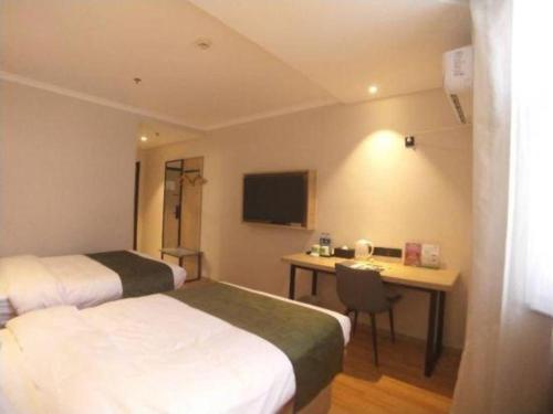 a hotel room with two beds and a desk at GreenTree Inn Xuzhou High Speed Railway Station Express Hotel in Xuzhou