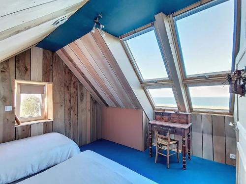une chambre avec deux lits, un bureau et des fenêtres dans l'établissement Mer et mare de Vauville, à Vauville