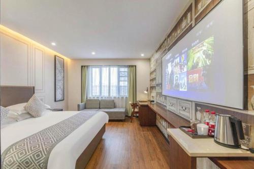 a hotel room with a large bed and a flat screen tv at GEM Hotel Ningbo Tongtu Road Minglou Metro Station in Ningbo