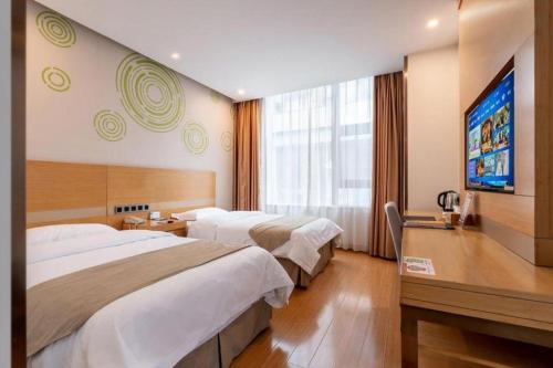 a hotel room with two beds and a flat screen tv at GreenTree Inn Suzhou Changshu North Haiyu Road Changhui Square Express Hotel in Changshu