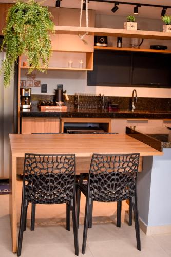 a kitchen with a wooden table and two chairs at Casa com vista para o mar e piscina em Milagres in São Miguel dos Milagres