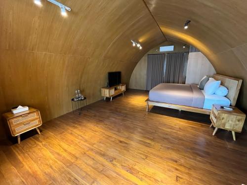 MungguにあるSkyloft Villa - 3 Bedrooms with Private Poolのベッドと木の床のある寝室