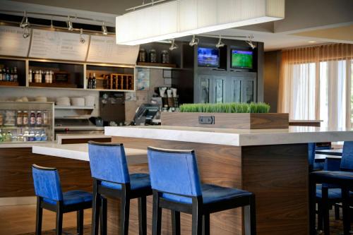 a bar with blue chairs in a restaurant at Courtyard Atlanta Marietta/I-75 North in Marietta