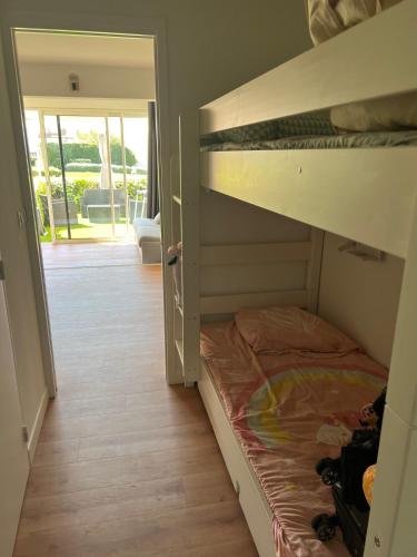 Ce lit superposé se trouve dans un dortoir doté d'une porte ouverte. dans l'établissement Joli studio climatisé vue mer, à Six-Fours-les-Plages