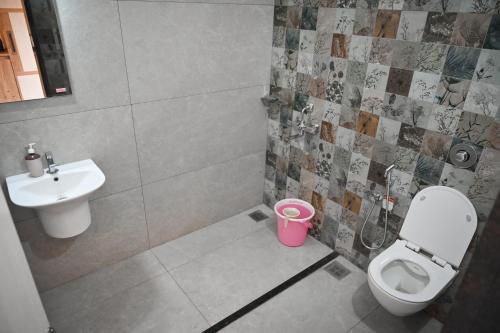 a bathroom with a toilet and a sink at Karkera's Beach Stay in Malpe