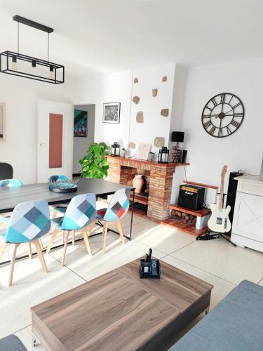 un salon avec une table et des chaises et une cheminée dans l'établissement Maison provençale les fourmis, aux Issambres